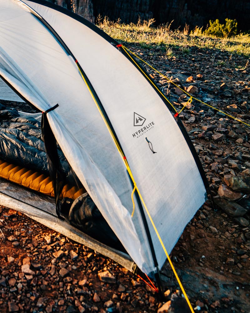 White camping tent with Hyperlite logo on a rocky ground