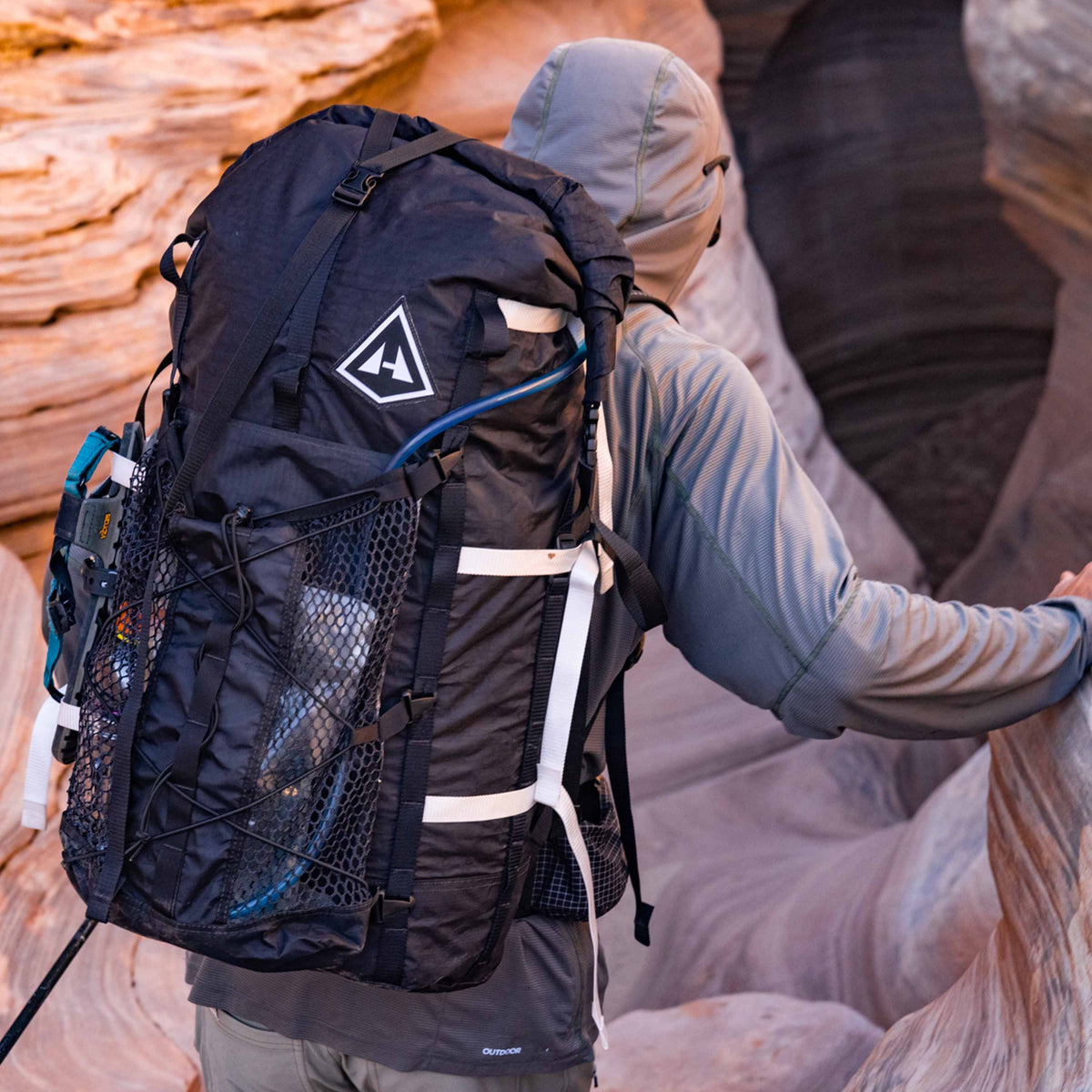 Hiker wearing Hyperlite Mountain Gear's Porter Stuff Pocket attached to their pack in the canyon