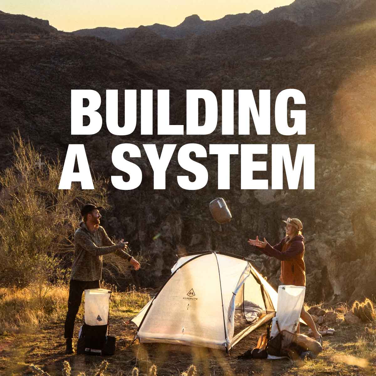 Two people setting up a tent in a desert landscape with text 'Building a System' overlayed.