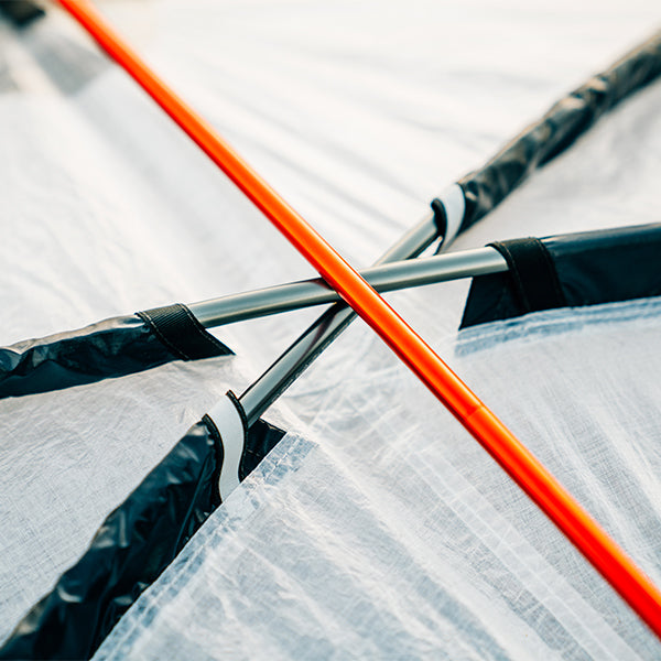Close-up of a tent's pole and fabric with a blurred background