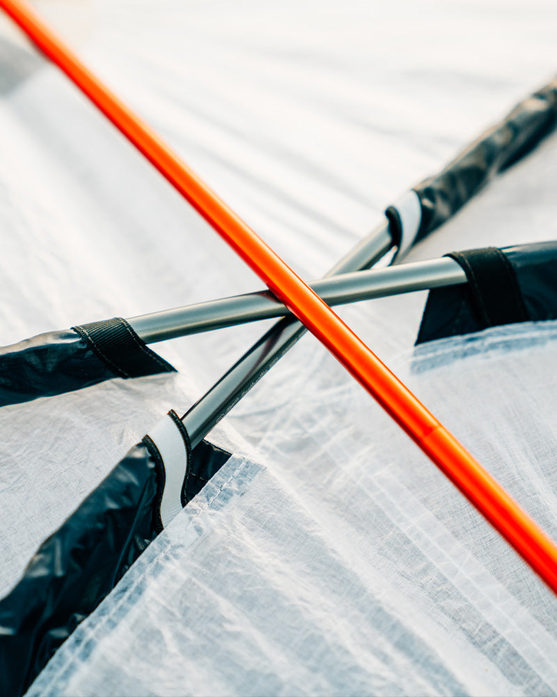 Close-up of orange rod and black straps on a white background
