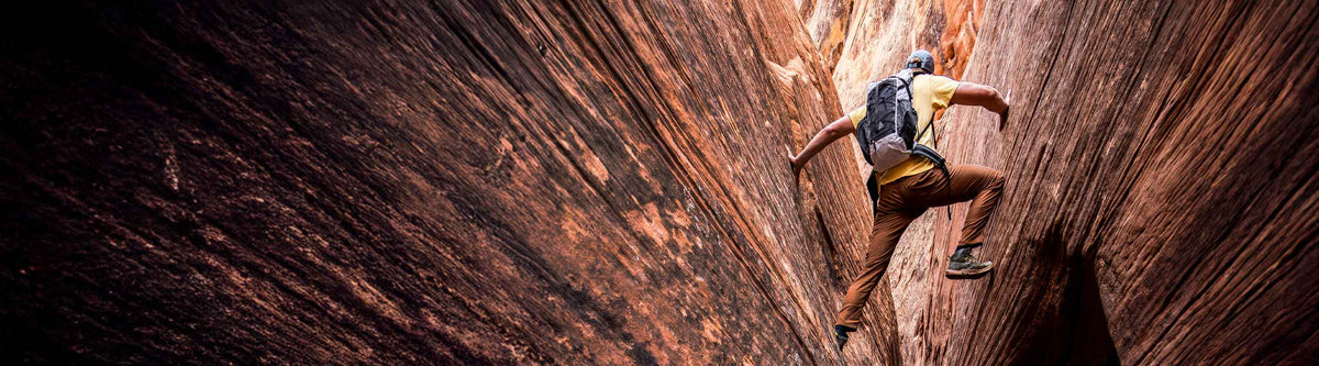 Person climbing a narrow rock formation