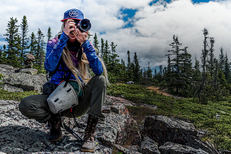 Person taking a photo in a mountainous forested area