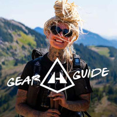 Person with tattoos and sunglasses holding a phone, with 'Gear Guide' and Hyperlite Mountain Gear logo overlay, against a mountainous background.