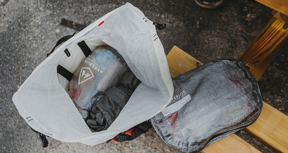 Hyperlite Mountain Gear stuff sacks organizing gear inside an ultralight backpack, with a Dyneema pods sitting next to it.